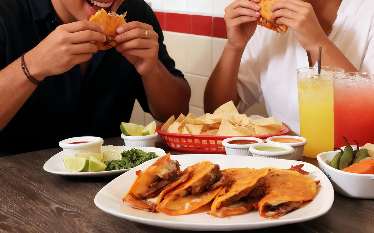 Couple eating tasty quesabirrias at Los Cazadores Taqueria