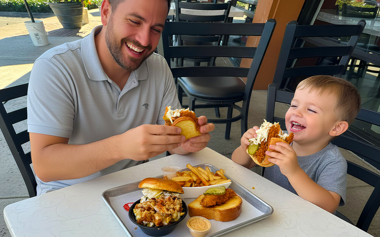 Father and son having a tasty chicken sandwich at The Tender Spot